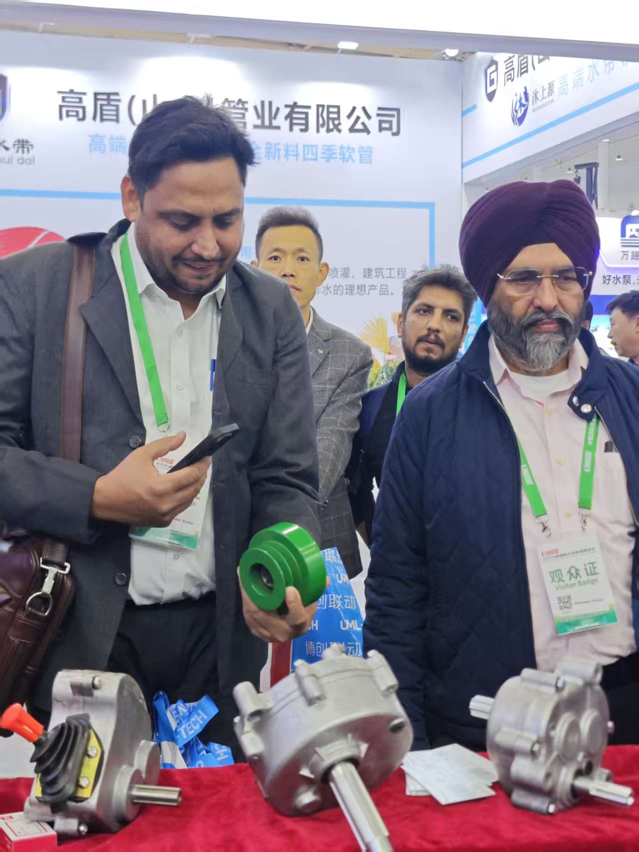 Visitors discussing agricultural machinery components